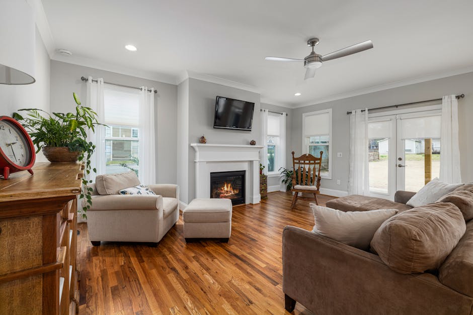 Inviting living room featuring a modern fireplace, soft sofas, and elegant wooden flooring.
