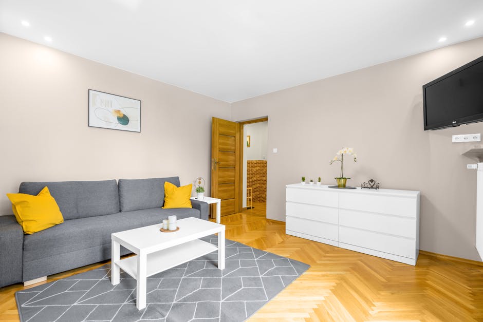 Contemporary living room in Warsaw with a grey sofa and yellow pillows, sleek interior design.