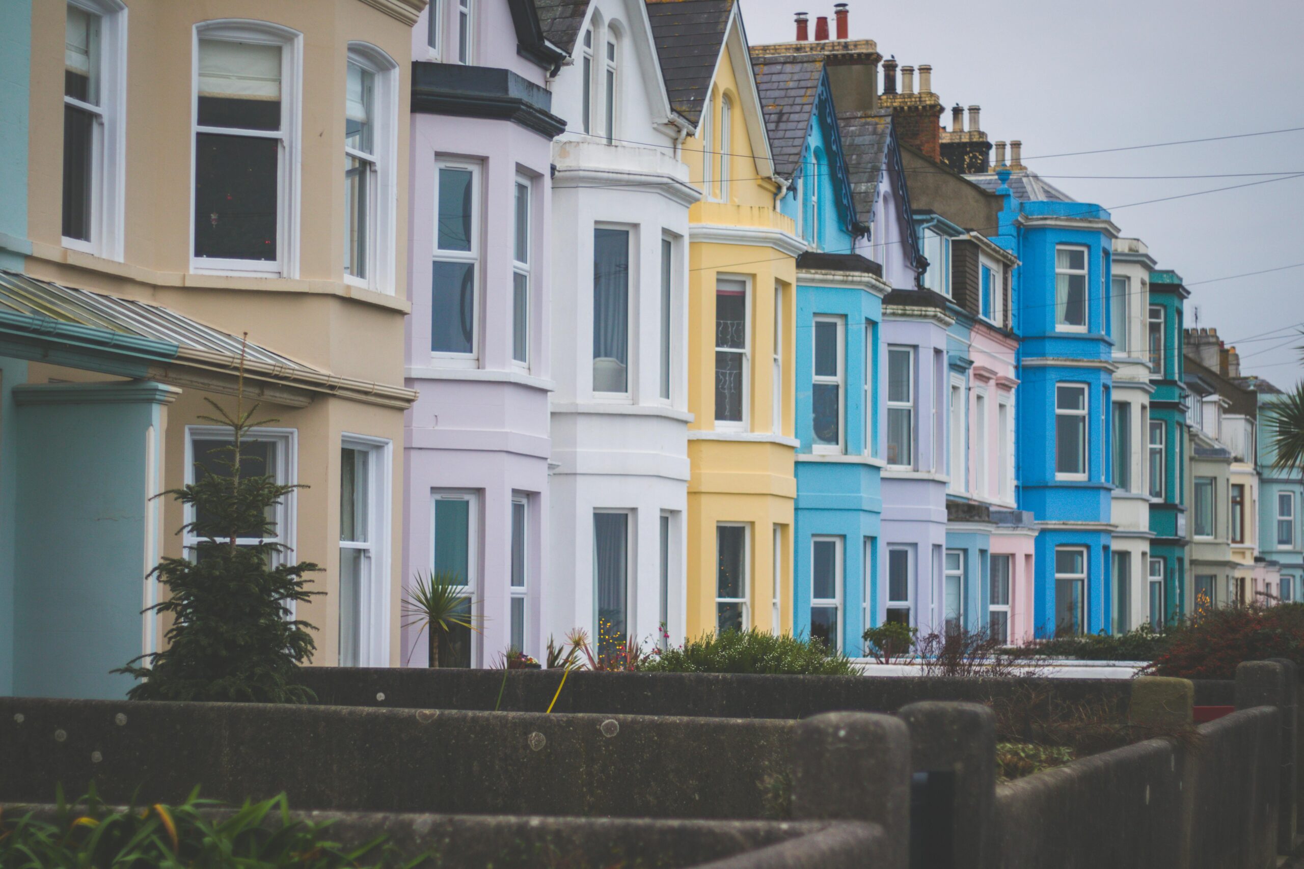Vibrant row of Victorian-style houses with colorful facades in a residential neighborhood.