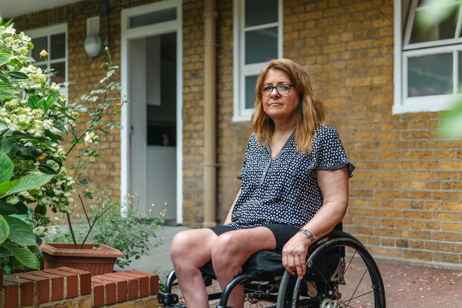 Confident woman sitting in a wheelchair beside a garden, conveying strength outdoors.